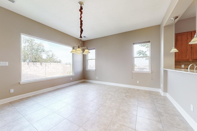 unfurnished dining area with a notable chandelier and light tile patterned floors