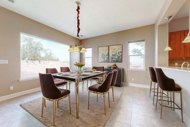 tiled dining room featuring a chandelier