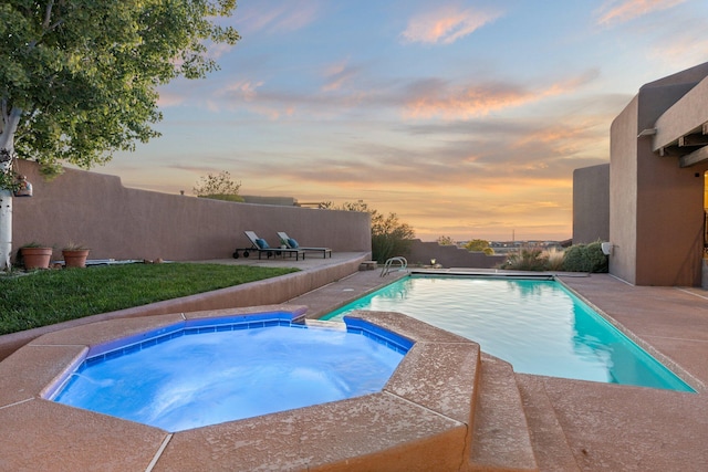 view of swimming pool with a pool with connected hot tub and fence