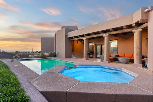 pool at dusk with an outdoor living space, an in ground hot tub, and a patio area