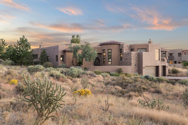 pueblo revival-style home featuring a garage