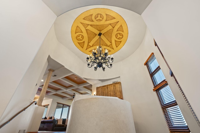 interior space featuring beamed ceiling, coffered ceiling, and a notable chandelier