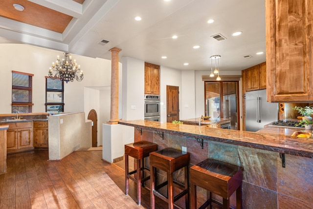 kitchen with stainless steel appliances, a breakfast bar, a peninsula, and visible vents