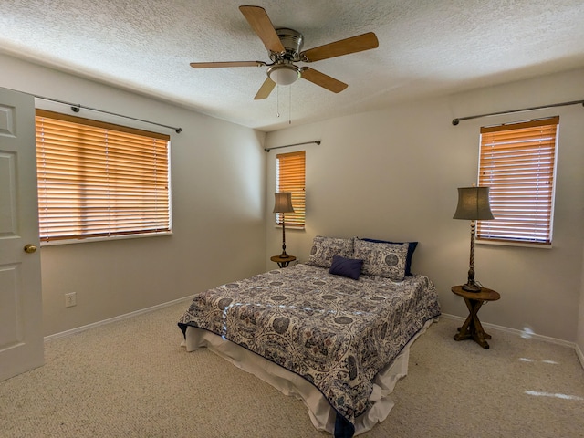 carpeted bedroom with multiple windows, a textured ceiling, and ceiling fan