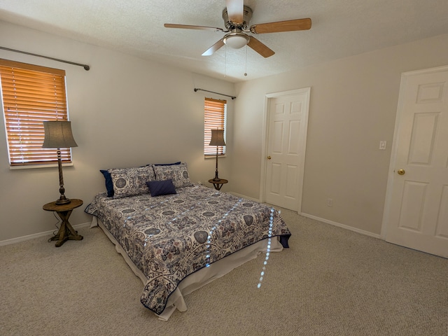 bedroom featuring ceiling fan, carpet flooring, and a textured ceiling