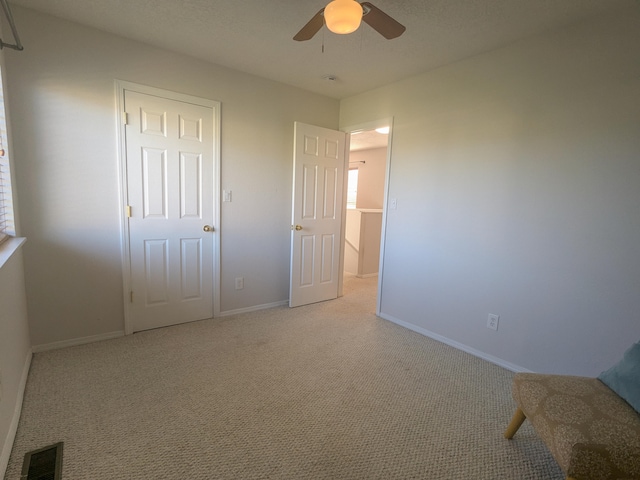 unfurnished bedroom with a closet, ceiling fan, and light colored carpet