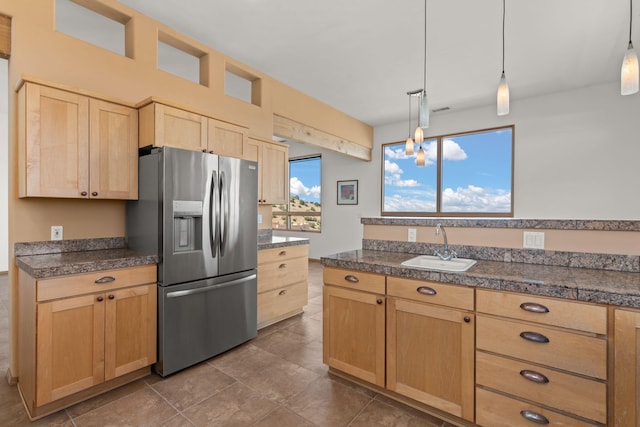 kitchen with a healthy amount of sunlight, light brown cabinets, hanging light fixtures, and stainless steel fridge with ice dispenser