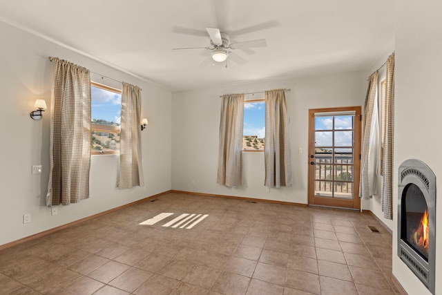 spare room with ceiling fan and light tile patterned floors