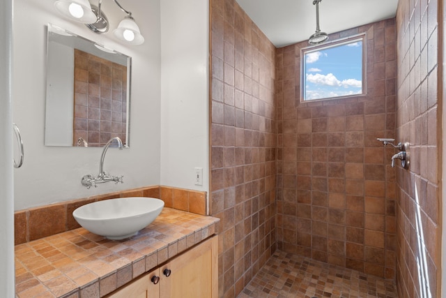 bathroom with vanity and tiled shower