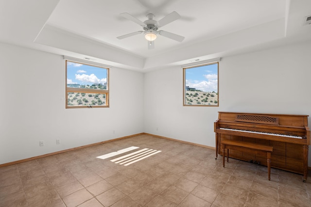 misc room with ceiling fan and a tray ceiling