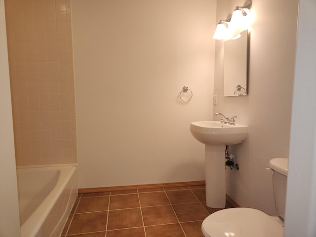 full bathroom featuring tiled shower / bath, sink, tile patterned floors, and toilet