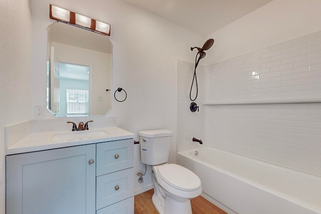 full bathroom featuring vanity, hardwood / wood-style flooring, tiled shower / bath combo, and toilet