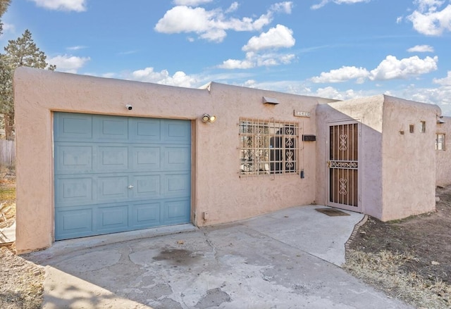 pueblo-style home featuring a garage