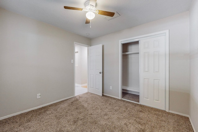 unfurnished bedroom featuring light carpet, a closet, and ceiling fan