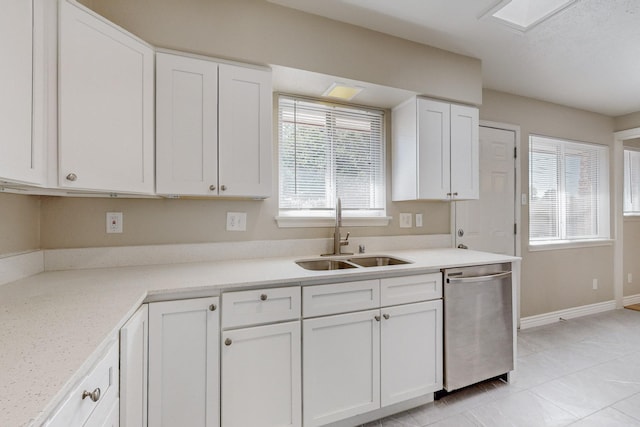 kitchen with a sink, baseboards, white cabinets, light countertops, and dishwasher