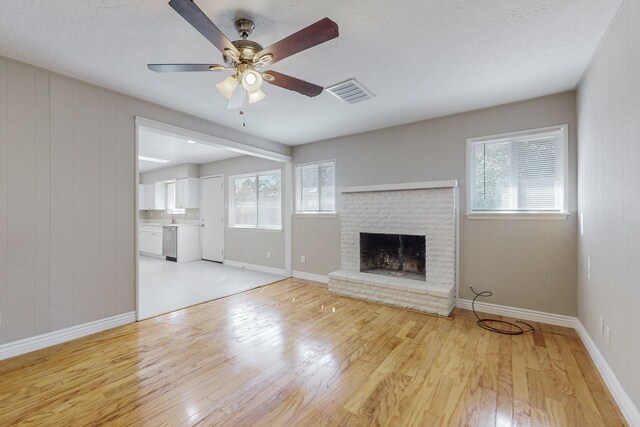 kitchen with light stone countertops, white cabinets, sink, a skylight, and appliances with stainless steel finishes