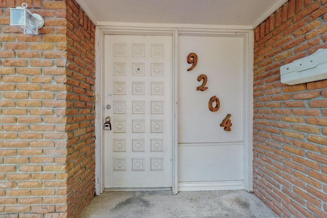 doorway to property featuring brick siding