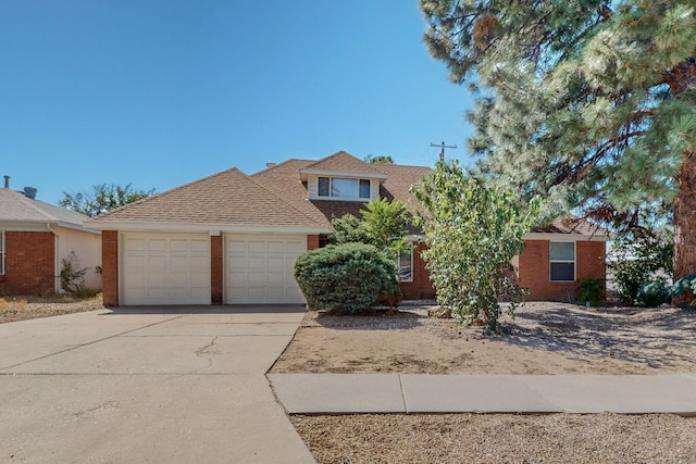 view of front of property featuring a garage, driveway, brick siding, and roof with shingles