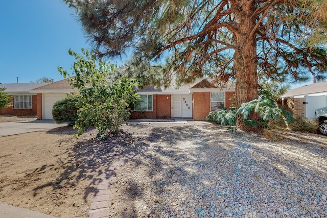 ranch-style home with concrete driveway, brick siding, and an attached garage