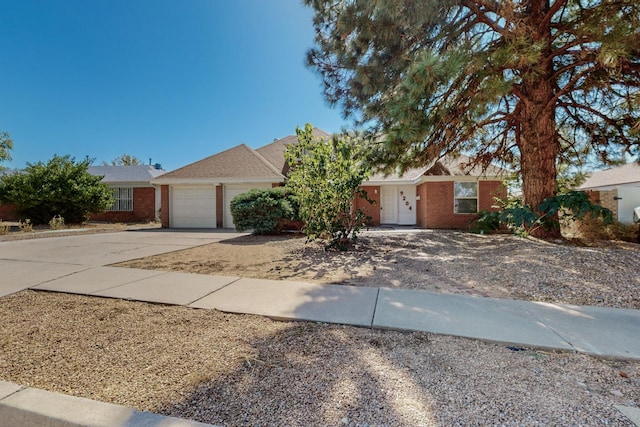 ranch-style house featuring concrete driveway, brick siding, and an attached garage