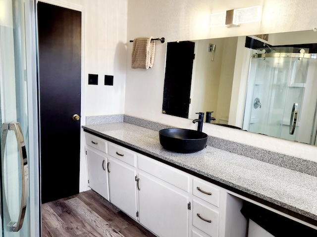 bathroom with vanity, an enclosed shower, and hardwood / wood-style flooring