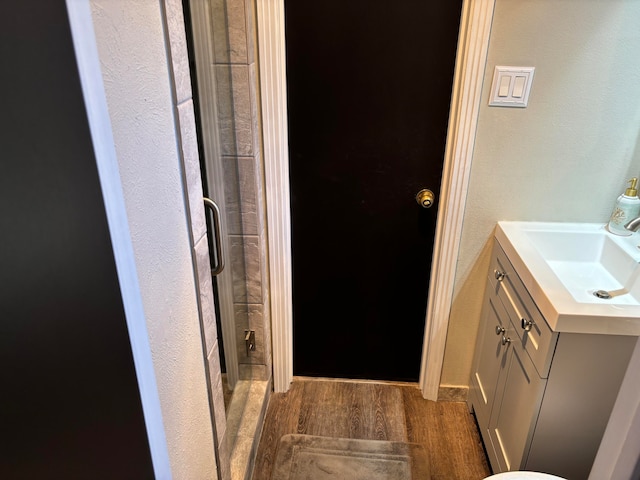 bathroom featuring walk in shower, hardwood / wood-style floors, and vanity