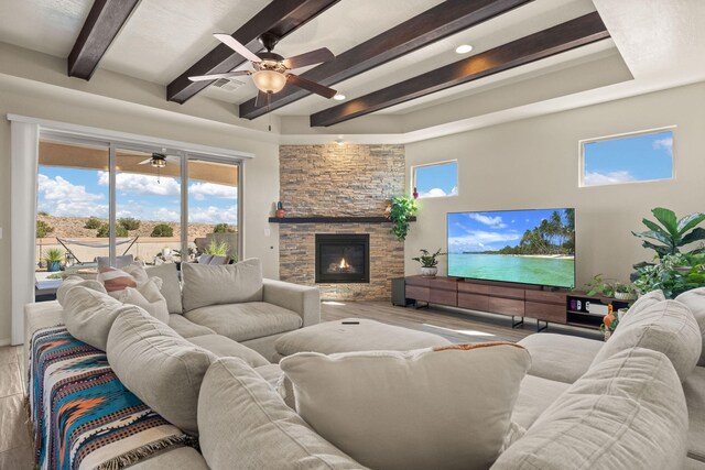 living room featuring beamed ceiling, hardwood / wood-style flooring, a fireplace, and a wealth of natural light