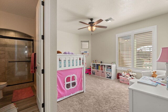 carpeted bedroom with a nursery area and ceiling fan