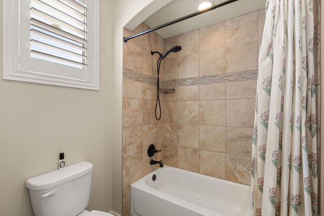 bathroom with shower / tub combo with curtain and toilet