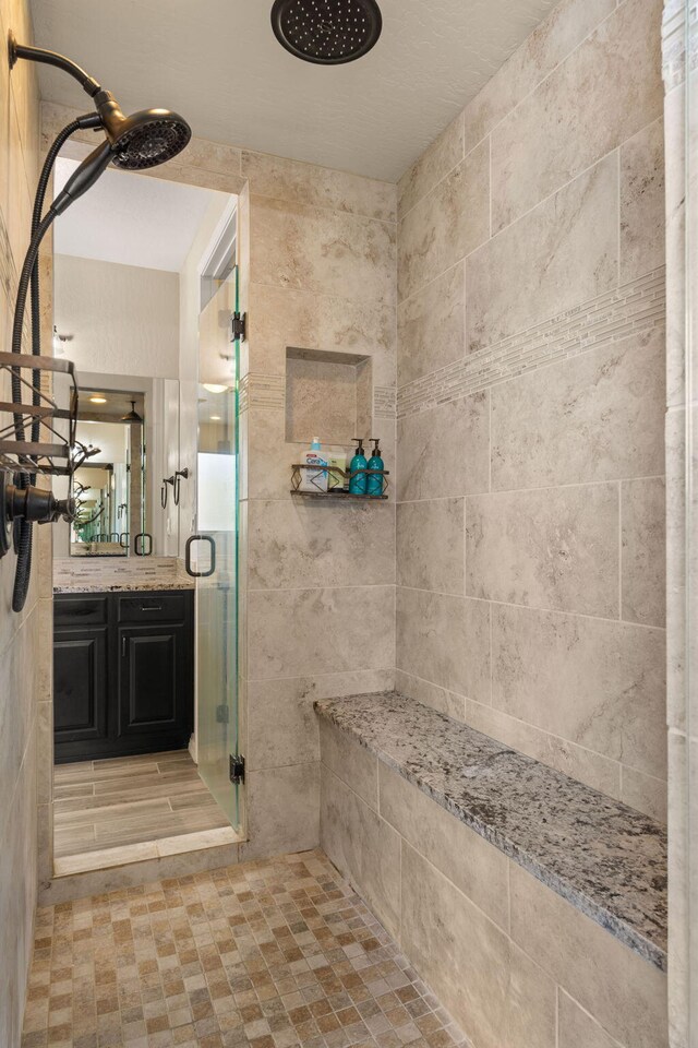 bathroom with a shower with door and vanity