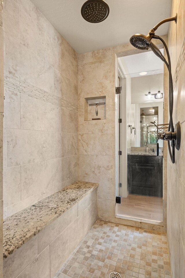 bathroom featuring walk in shower and vanity