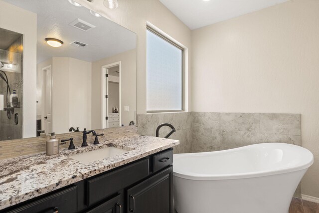 bathroom with vanity and independent shower and bath