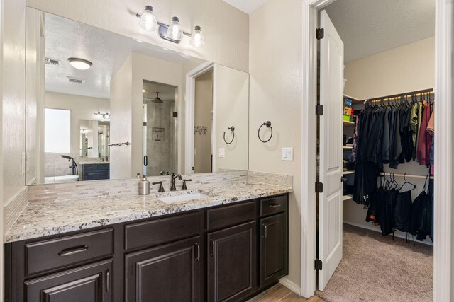 bathroom with vanity, an enclosed shower, and a textured ceiling