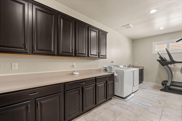 washroom with hookup for a washing machine, cabinets, a textured ceiling, and light tile patterned flooring