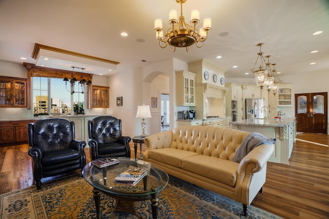 living room featuring a chandelier, dark hardwood / wood-style floors, and sink