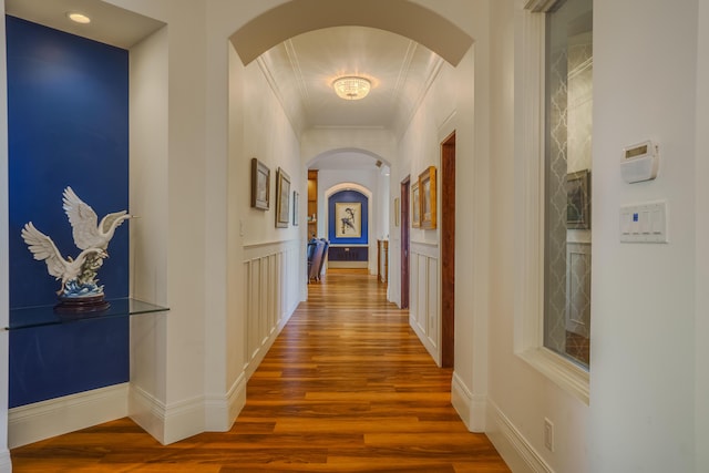 hallway with hardwood / wood-style floors and ornamental molding