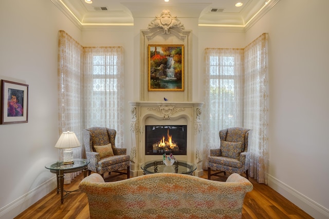 sitting room featuring plenty of natural light, wood-type flooring, and crown molding