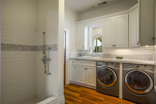 clothes washing area with dark hardwood / wood-style flooring, separate washer and dryer, and sink