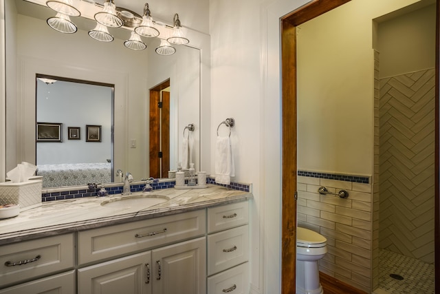 bathroom with vanity, tile walls, and toilet