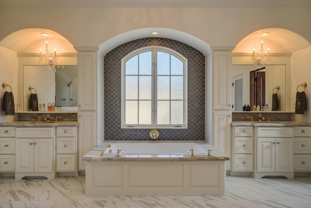 bathroom featuring decorative columns, a washtub, and vanity