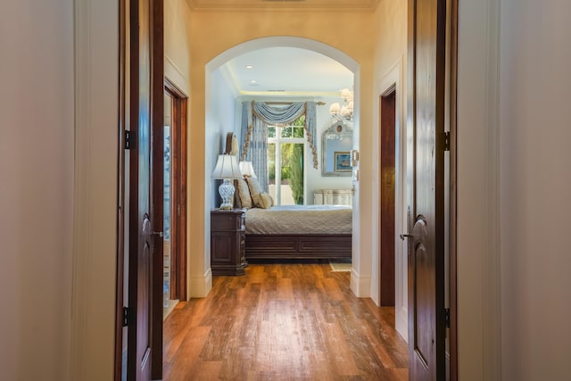 hallway with dark hardwood / wood-style floors and ornamental molding