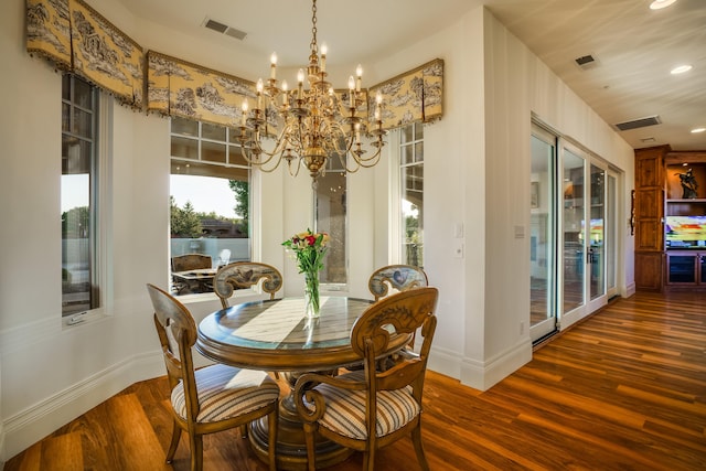 dining space featuring dark hardwood / wood-style flooring and an inviting chandelier