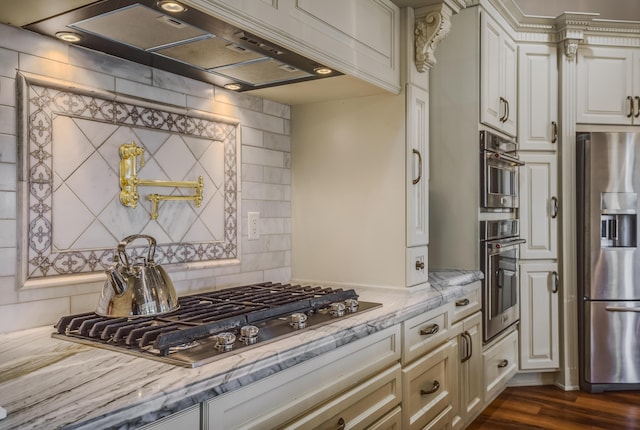 kitchen with light stone countertops, stainless steel appliances, dark hardwood / wood-style flooring, decorative backsplash, and exhaust hood