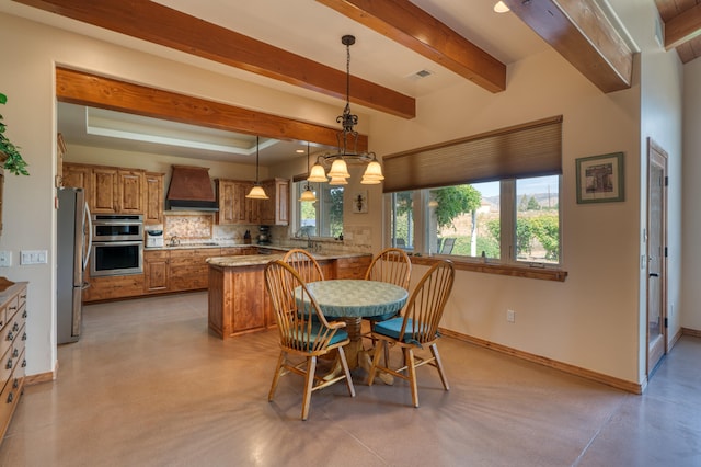 dining space featuring beam ceiling and sink