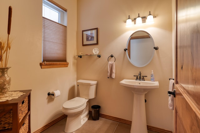 bathroom with toilet, tile patterned floors, and sink