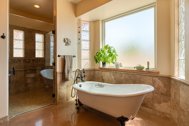 bathroom with tile walls and plus walk in shower