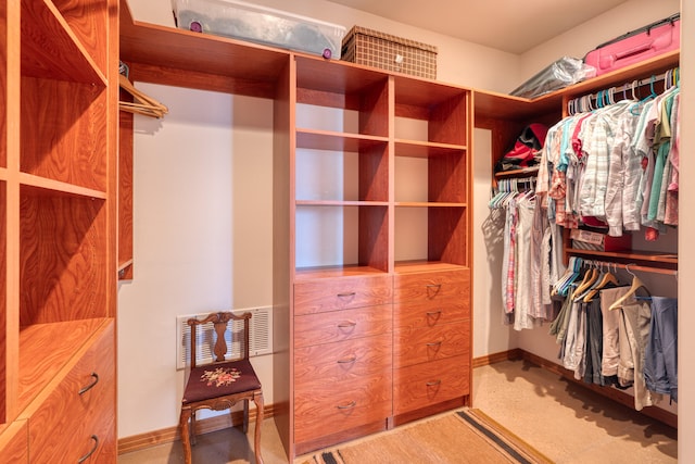 walk in closet featuring light colored carpet