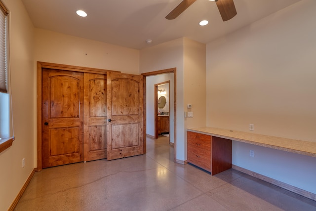 interior space with ceiling fan and built in desk