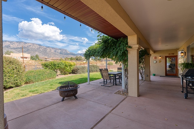 view of patio with a mountain view and a fire pit