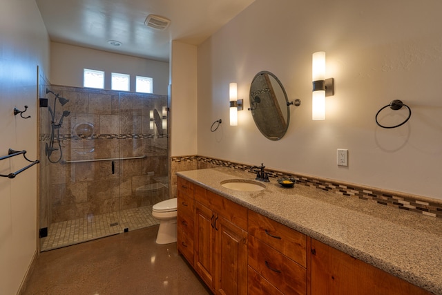 bathroom featuring vanity, toilet, and a shower with door